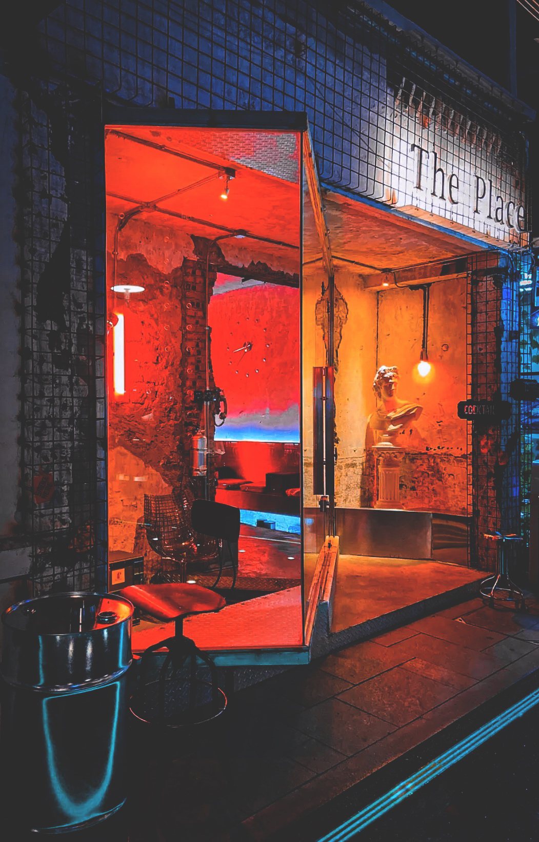 THE PLACE storefront at night — red neon glowing through a half-ruined wall on Wangping Street